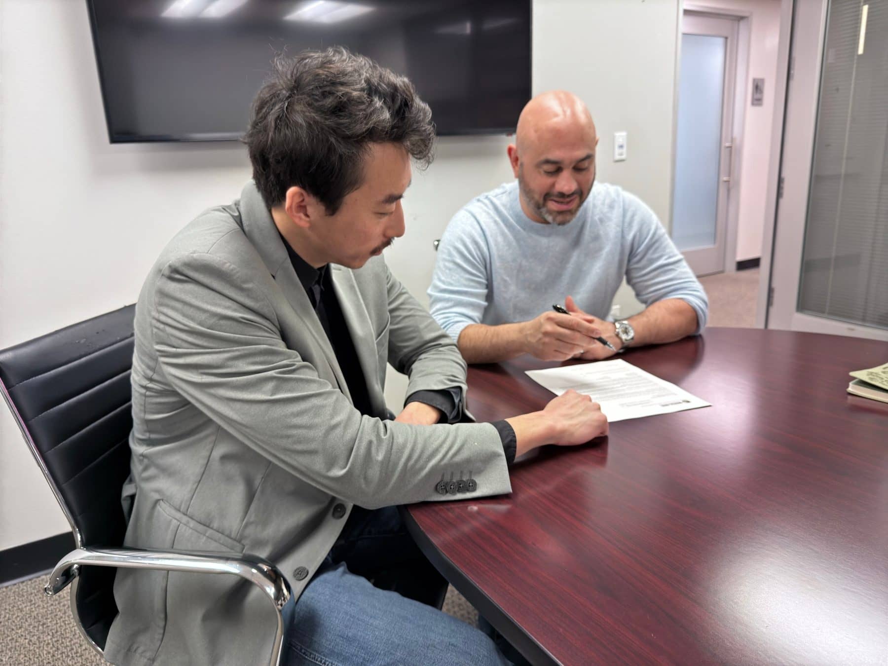 Serge Bagdasarov reviewing a policy with a client at the Absolute Insurance Solutions office in Kirkland, WA